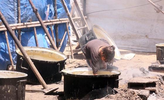 فتاة نازحة في غزة تحاول جمع بقايا الطعام المتبقية من قدر الطهي.